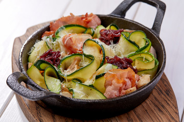 roasted vegetables with bacon on the wooden background