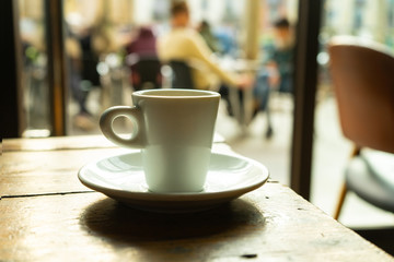Cup of coffee in a nice hipster cafe. Soft focused image. Cup of espresso on old table of cafeteria. 