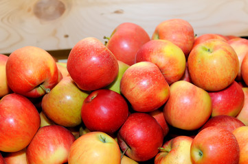 Red fresh apples in a pile on a wooden box