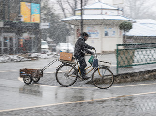 Fototapeta na wymiar Cyclist on the city roadway on a rainy day in motion blur