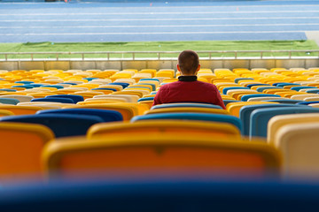 spectators watch football in a half-empty stadium