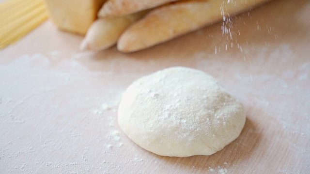 Close up view of baker hands kneading the dough on the table. Manufacturing process, working hard. Making bread, bread production. Workplace