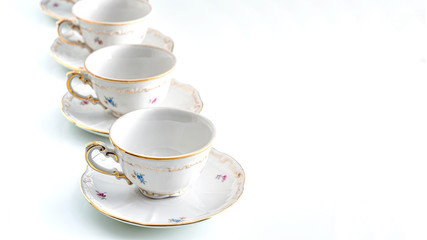 Cups and saucers standing one after another on a white background