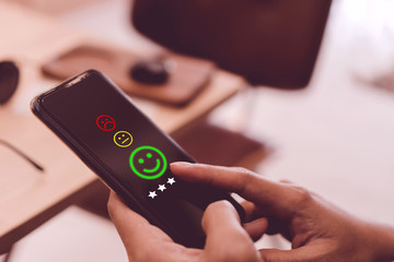 Smile face to not smile face and 5 stars icon on smartphone screen. Optimistic person or people...