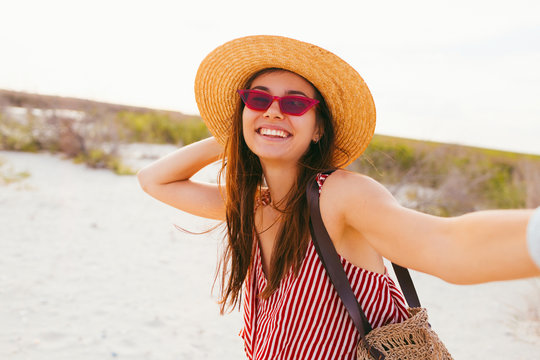 Image of happy young excited asian lady make selfie by camera on the beach. Photo of cute young emotional caucasian lady make selfie by camera on the beach
