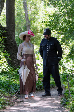 Elegant Lady, From The High Society Of The Twentieth Century, Walking With A British Policeman In A Public Park