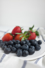 Beautiful healthy breakfast plate with strawberries and blueberries on a checkered napkin 