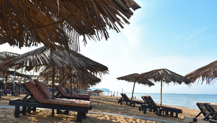 chair with leaf umbrella in the beach of Goa for relaxing