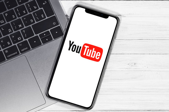 YouTube logo on the screen smartphone and notebook closeup background. YouTube is a free video sharing application that anyone can watch. Moscow, Russia - December 27, 2019