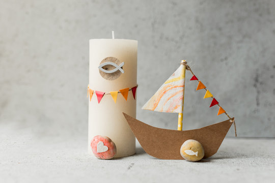 kommunion, konfirmation, firmung, taufe, glaube - Segelboot gebastelt aus Papier mit Girlande in gelb, orange, rot und weiß mit Kerze