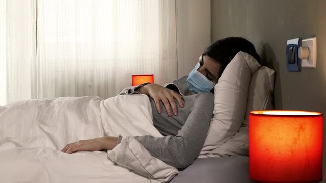 Woman with coronavirus in hospital in bed coughing sick