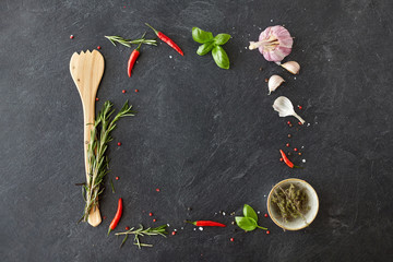 food, culinary and eating concept - rosemary, garlic, thyme and red chili pepper on stone surface