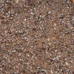 Tecture of a sand with little seashore rocks. Top view with copy space
