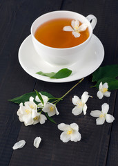 Jasmine flowers and cup of fragrant tea