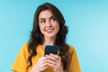 Smiling young girl using mobile phone.