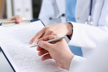 Female doctor hand hold silver pen and showing pad. Physical agreement form signature disease...