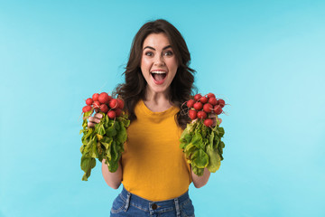 Excited young girl holding radish.