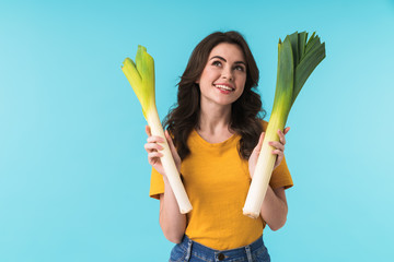 Positive young girl holding leek.