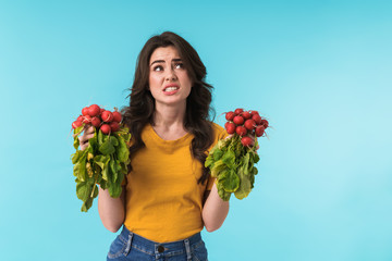 Confused sad young girl holding radish.