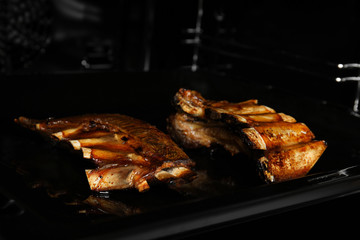 Delicious roasted ribs on baking sheet in oven