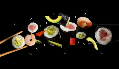 Delicious sushi rolls and ingredients on black background © New Africa