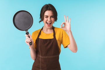 Happy young woman chef holding frying pan