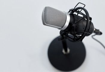technology and audio equipment concept - close up of microphone on white background