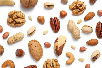 Different delicious nuts on white background, flat lay