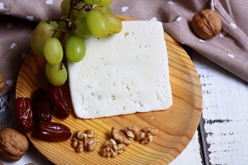 queso curado de oveja acompañado de nueces, dátiles y uva blanca.	