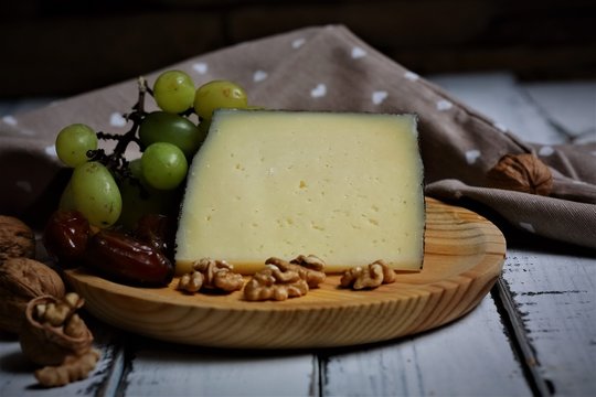 semi-cured goat cheese, accompanied by white grapes, nuts and dates. - Powered by Adobe