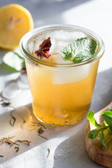 Kombucha Tea or iced tea beverage. Fermented Super Food, Pro Biotic summer  drink In Glass with mint , Lemon, On concrete  Table, outdoor. Copy space.