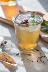 Kombucha Tea or iced tea beverage. Fermented Super Food, Pro Biotic summer  drink In Glass with mint , Lemon, On concrete  Table, outdoor. Copy space.