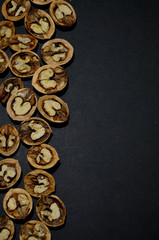 walnut halves on a black background left side top view vertical orientation