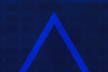 Vivid blue geometric background with triangle or pyramid. Bright blue fabric with metal lattice underneath. Modern building door close up. Copy space