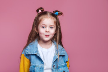 funny little kid girl in denim jacket isolated on pink