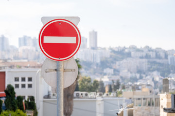 Red do not enter road sign with an Israeli town Haifa on the background