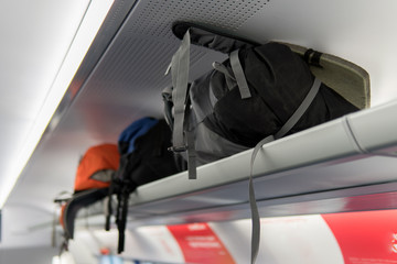 Backpacks lying on the shelf in the train