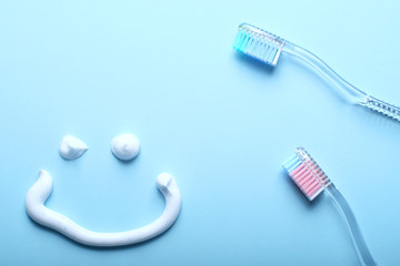 Toothbrushes and a smiling face on blue background