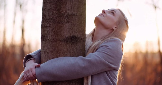 beautiful loving nature woman hugs tree in forest in autumn