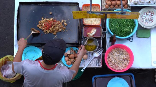 Kota Kinabalu, Malaysia - february 24, 2020 : Man cooking Chinese traditional appetizer is the Chai Taw Kway or Kuih Lobak Goreng in Malay and fried radish cake in English, street market