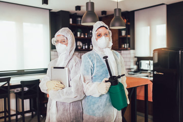Specialists in protective suits do disinfection or pest control in the apartment.