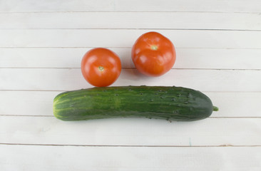  cucumber and two tomatoes lie on the kitchen table
