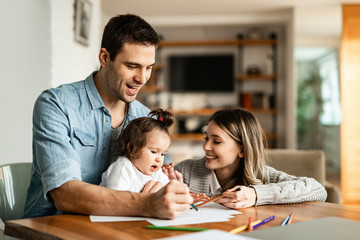 Young happy family having fun while drawing at home.