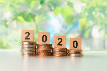 Wooden block year 2020 on stack coins using as business and financial concept