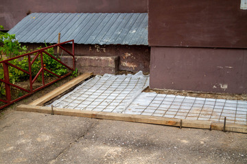 Repair of the blind area at the apartment building. Preparation for pouring concrete. The installation of an iron . Casing made of boards.