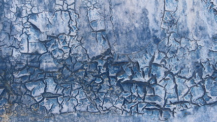 cracks and flakes in the detailed texture of old blue paint