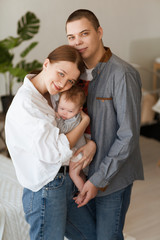 Fototapeta premium young parents holding their newborn baby daughter at home
