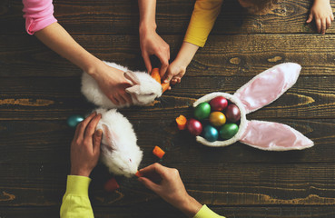 Happy easter! Father and kid painting Easter eggs - top view. Rabbit's family with bunny ears. Egg surprise toys. - 327806417