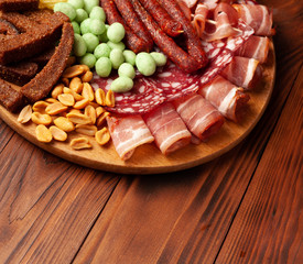 Set of snacks on a wooden board for beer and alcohol. Stock photo appetizer in a bar.