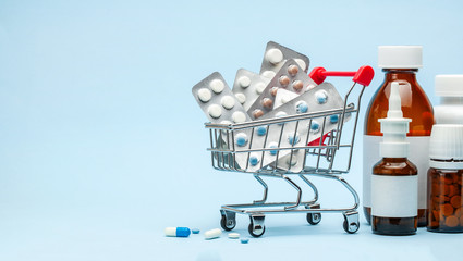 Shopping trolley and medicine. Expensive medicine. Shopping basket with blisters with pills and...